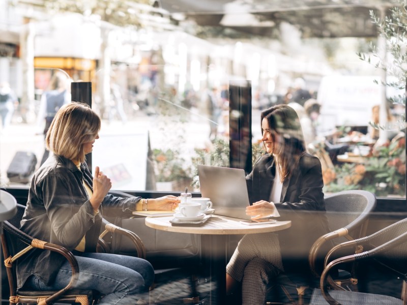 Zwei Frauen unterhalten sich über geschäftliches in einem Restaurant.