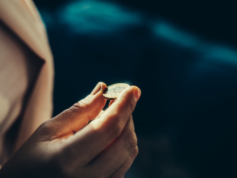 Eine Frau hält eine Ein-Euro-Münze in der Hand.
