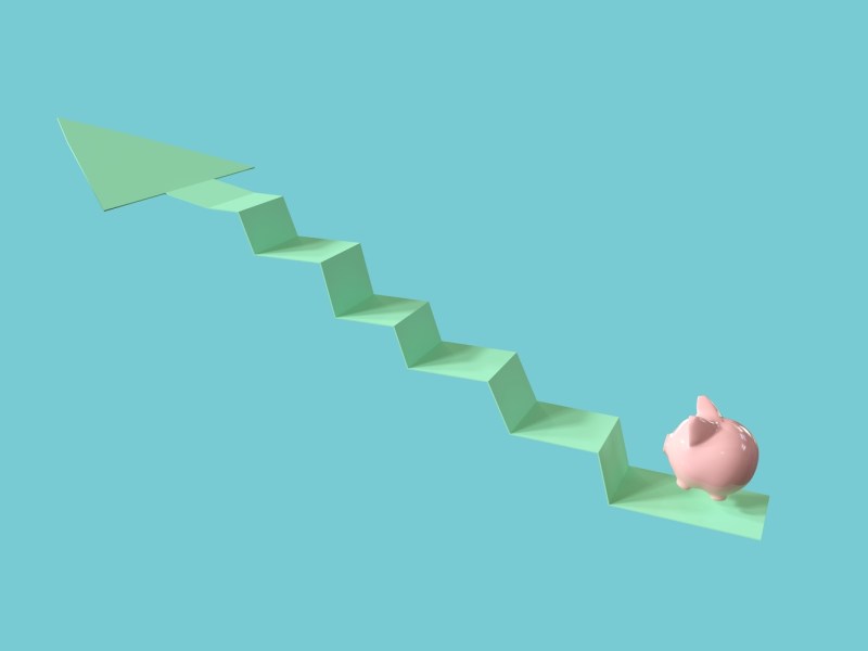 Ein pinkes Sparschwein springt auf einen Pfeil nach oben. Vor blauem Hintergrund.