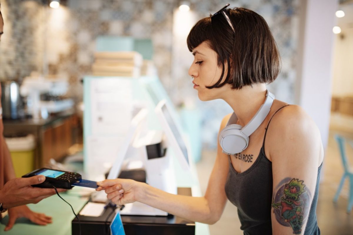 junge frau bezahlt im laden mit bankkarte