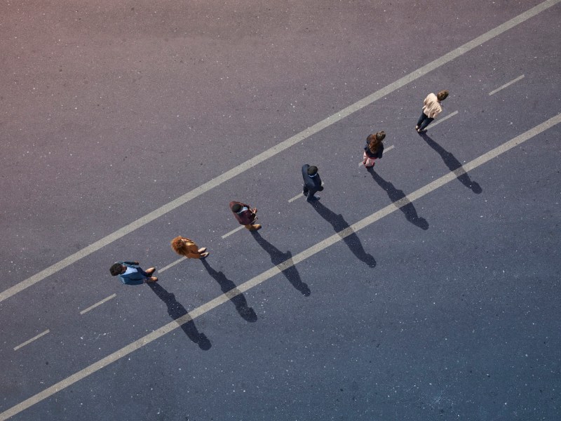 Eine Gruppe junger Erwachsener, von oben fotografiert, auf verschiedenen bemalten Asphaltflächen.