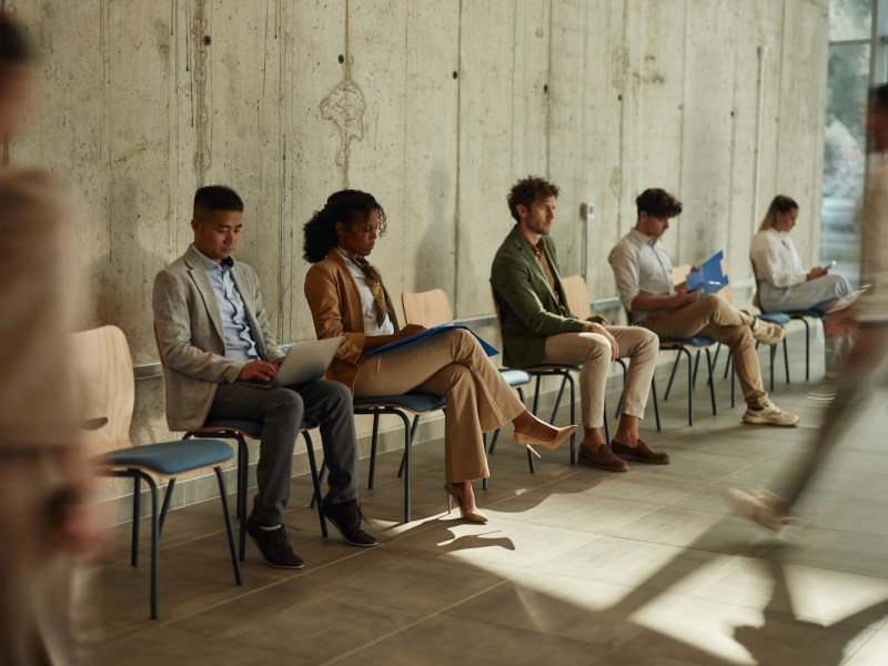 Eine Gruppe von Bewerber*innen wartet auf das Vorstellungsgespräch.