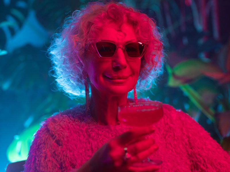 Oma trinkt aus einem Cocktail-Glas