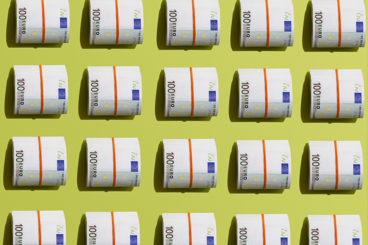 Rolle mit Hundert-Euro-Banknoten auf hellgrünen Hintergrund.