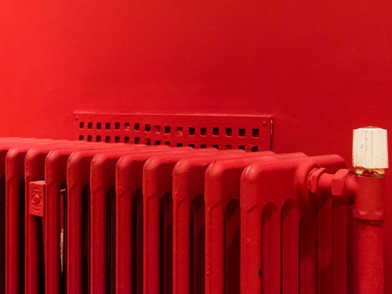 Rote Heizung vor einer roten Wand