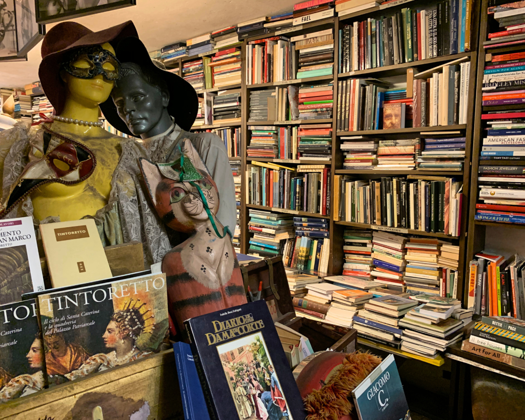 Der Name bedeutet übersetzt „Hochwasser-Buchhandlung“ und bezieht sich auf das venezianische Hochwasser, das die Bücher vor Überschwemmungen schützt.