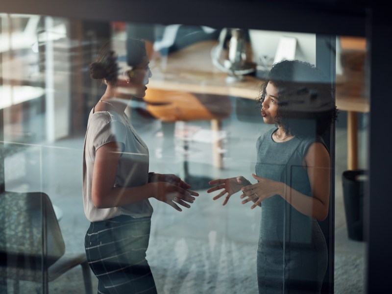 Zwei Frauen führen in einem Meetingraum eine Unterhaltung.
