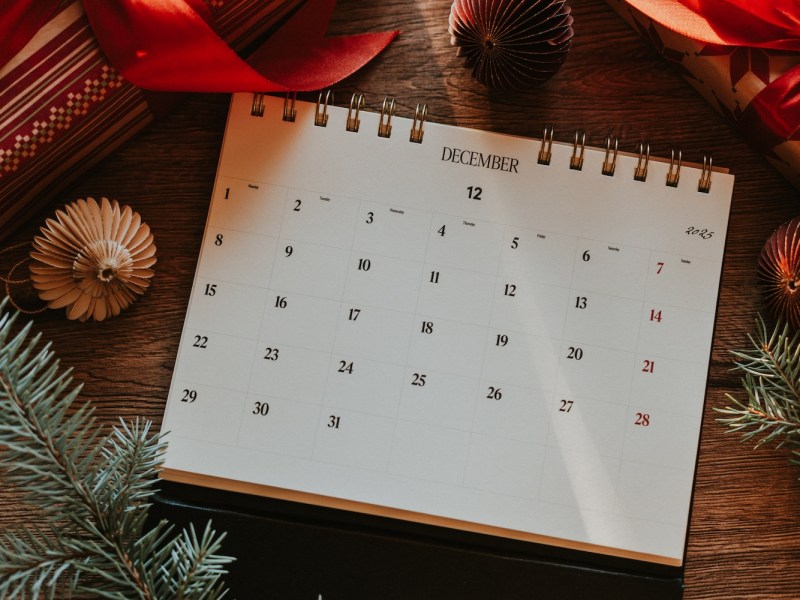 Ein festlicher Dezemberkalender, geschmückt mit weihnachtlicher Dekoration und Geschenkpapier, der die Weihnachtsstimmung versprüht.