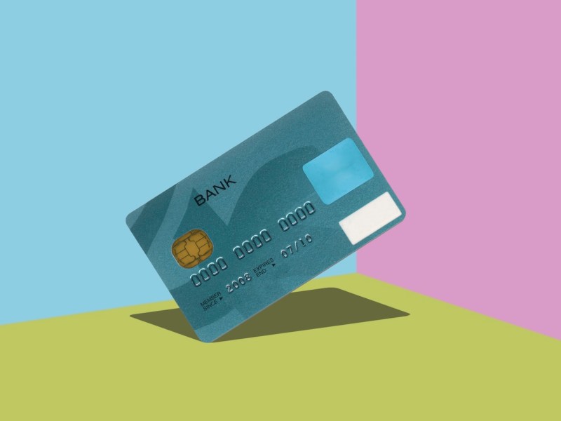 Kreditkarte schwebt vor surrealem Hintergrund.