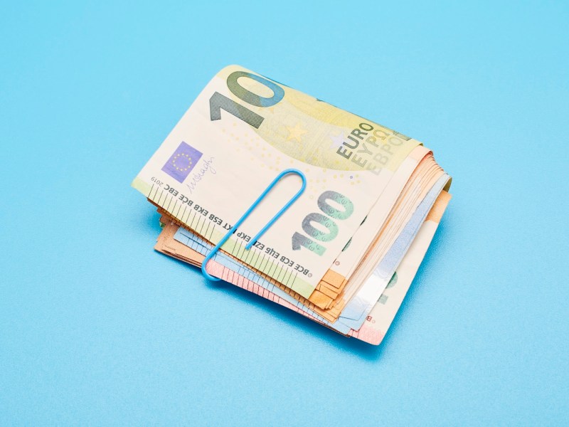 Stillleben eines Bündels Euro-Banknoten auf blauem Hintergrund