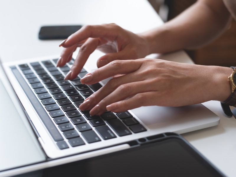 Eine Frau tippt auf dem Laptop.