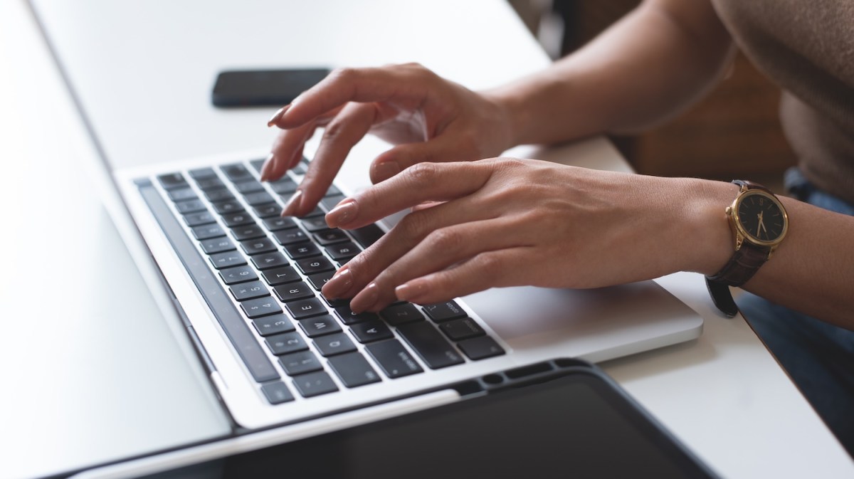 Eine Frau tippt auf dem Laptop.