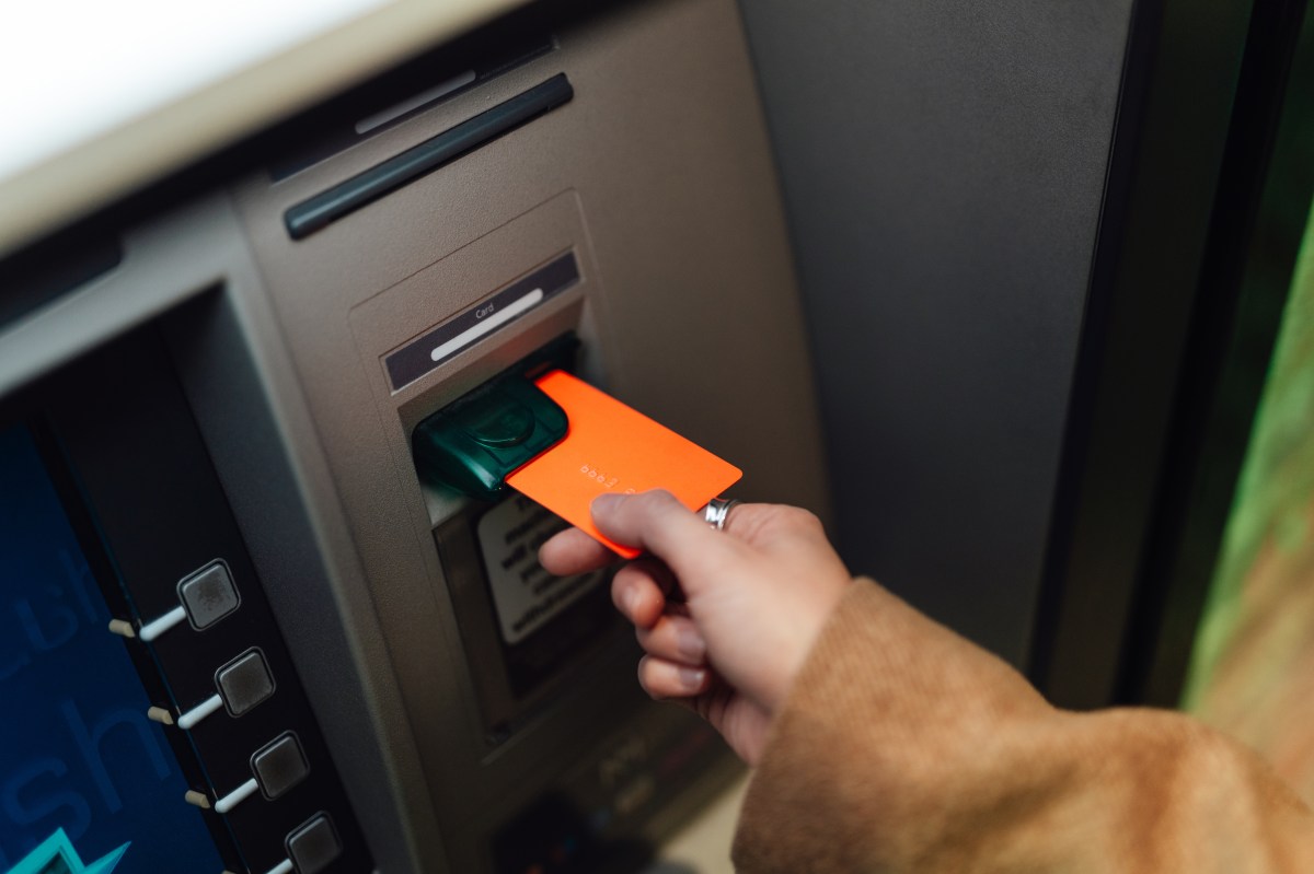 Eine Frau hebt mit ihrer Bankkarte Geld ab.