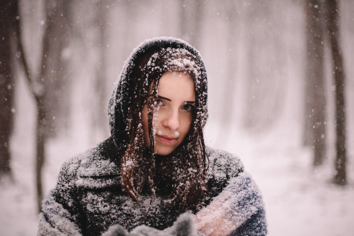 Wintereinbruch Frau im Schnee mit Mütze Auswirkungen Psyche