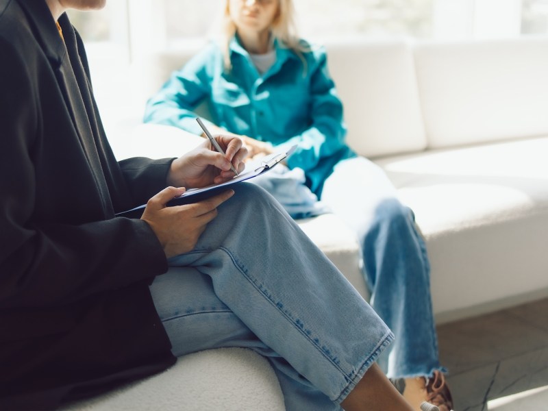 Zwei Frauen sitzen in Sesseln und unterhalten sich.