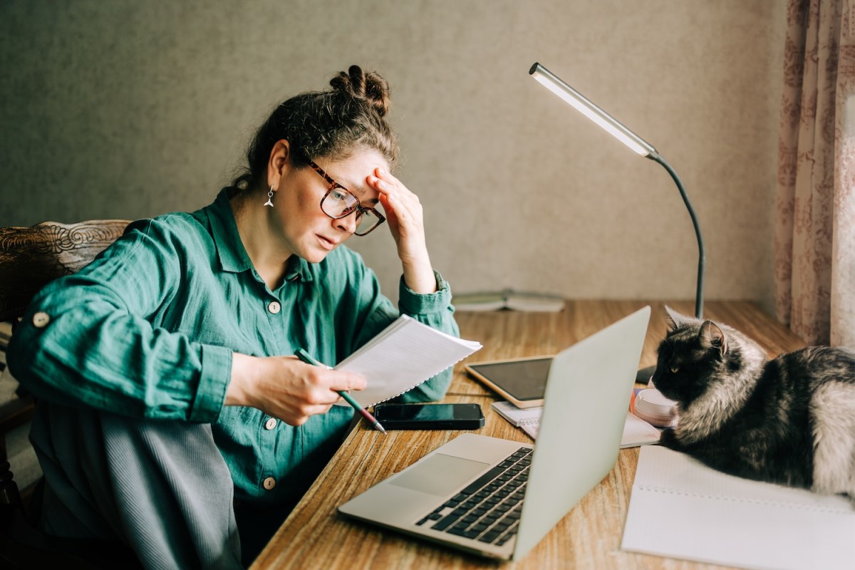 Frau schaut besorgt auf ihre Lernunterlagen.