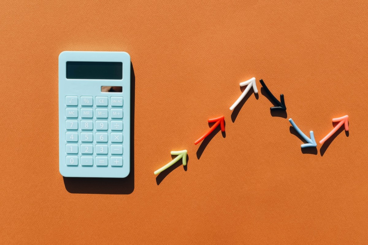 Blauer Taschenrechner und ein Diagramm aus farbigen Pfeilen.