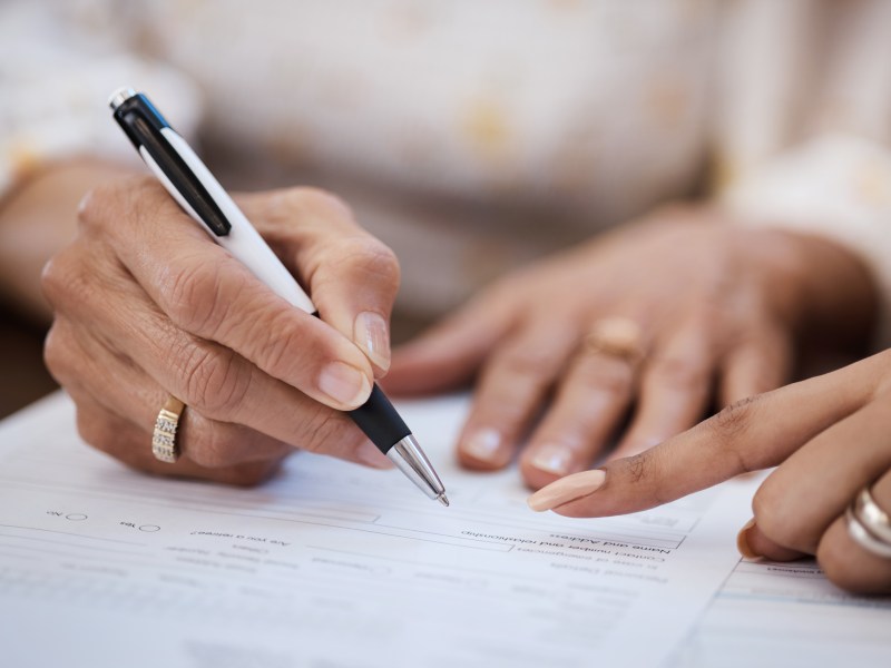 Frau hält Stift in den Händen auf Papier