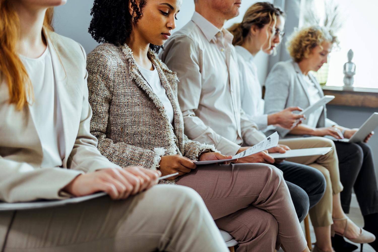 Eine Gruppe junger Menschen warten auf ein Vorstellungsgespräch.