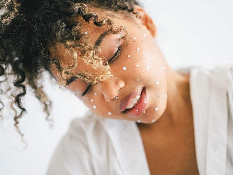 Frau mit Glitzersteinen im gesicht lacht