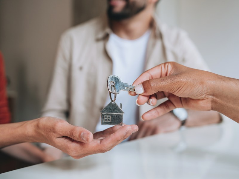 Zwei Menschen übergeben Schlüssel