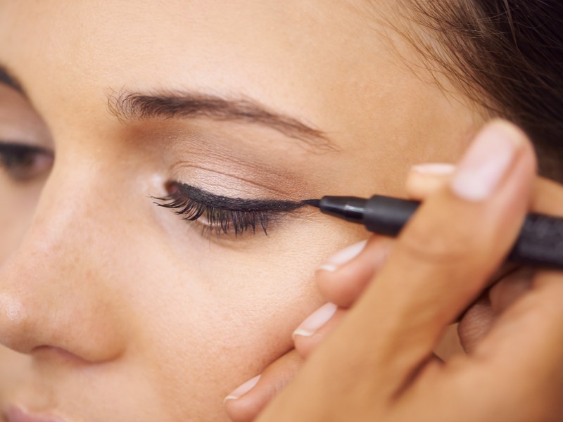 Frau zieht sich Eyeliner