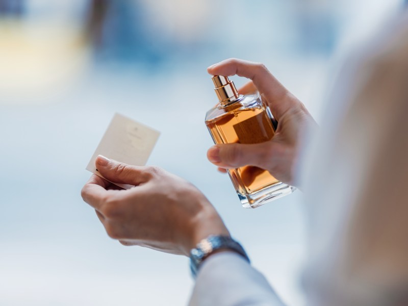 Eine Frau sprüht Parfum auf einen Tester